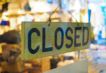 Closed sign in a shop showroom with selective focus and blurred background