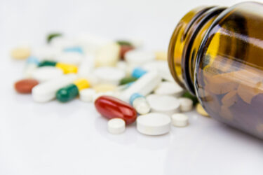 Medical pills placed on rotating table, shot with white seamless