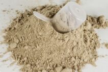 A pile of chocolate protein powder with a scoop.