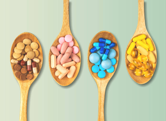 Mix of dietary supplements and OTC health products on wooden spoons