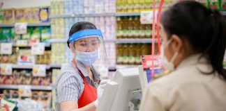 female supermarket cashier in medical protective mask working at supermarket. covid-19 spreading outbreak
