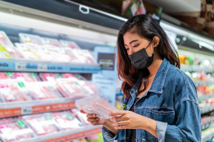 Young Asian woman wearing face mask in grocery store