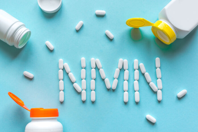 White pills forming shape to NMN alphabet on blue background, copy space, top view.
