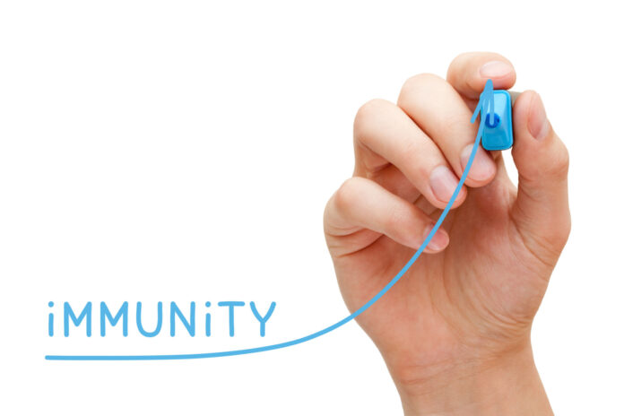 Hand drawing increasing Immunity graph with blue marker on transparent wipe board isolated on white.