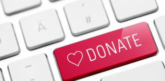 Zoomed-in image of a keyboard, centering a bright red button featuring a heart symbol and the word "Donate."