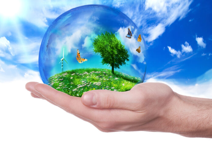 hand holding a planet represented by a green nature and a serene environment and ecological
